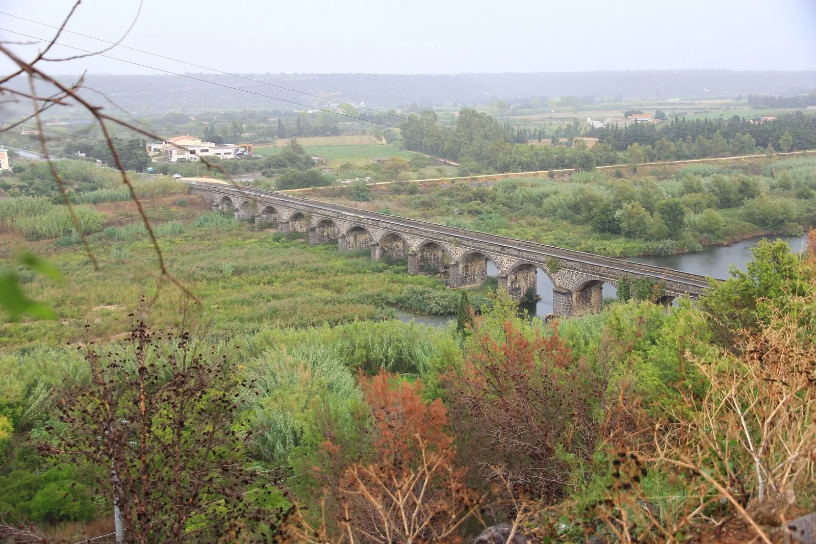 Ponte ad arcate in pietra sul fiume Cedrino nella piana verde di Orosei