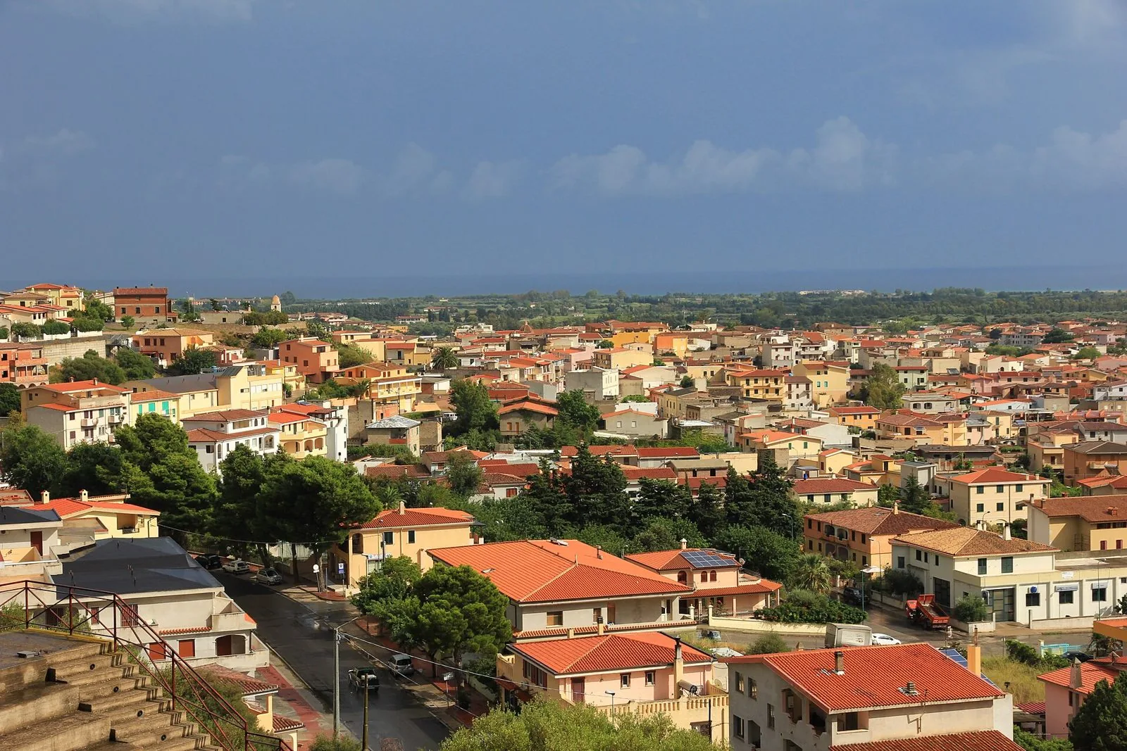 Veduta dall'alto dei tetti di Orosei con la pianura costiera e il mare all'orizzonte