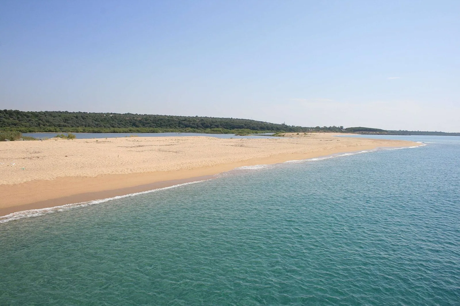 Lungo arenile dorato di Marina di Orosei con acqua turchese e macchia mediterranea sullo sfondo